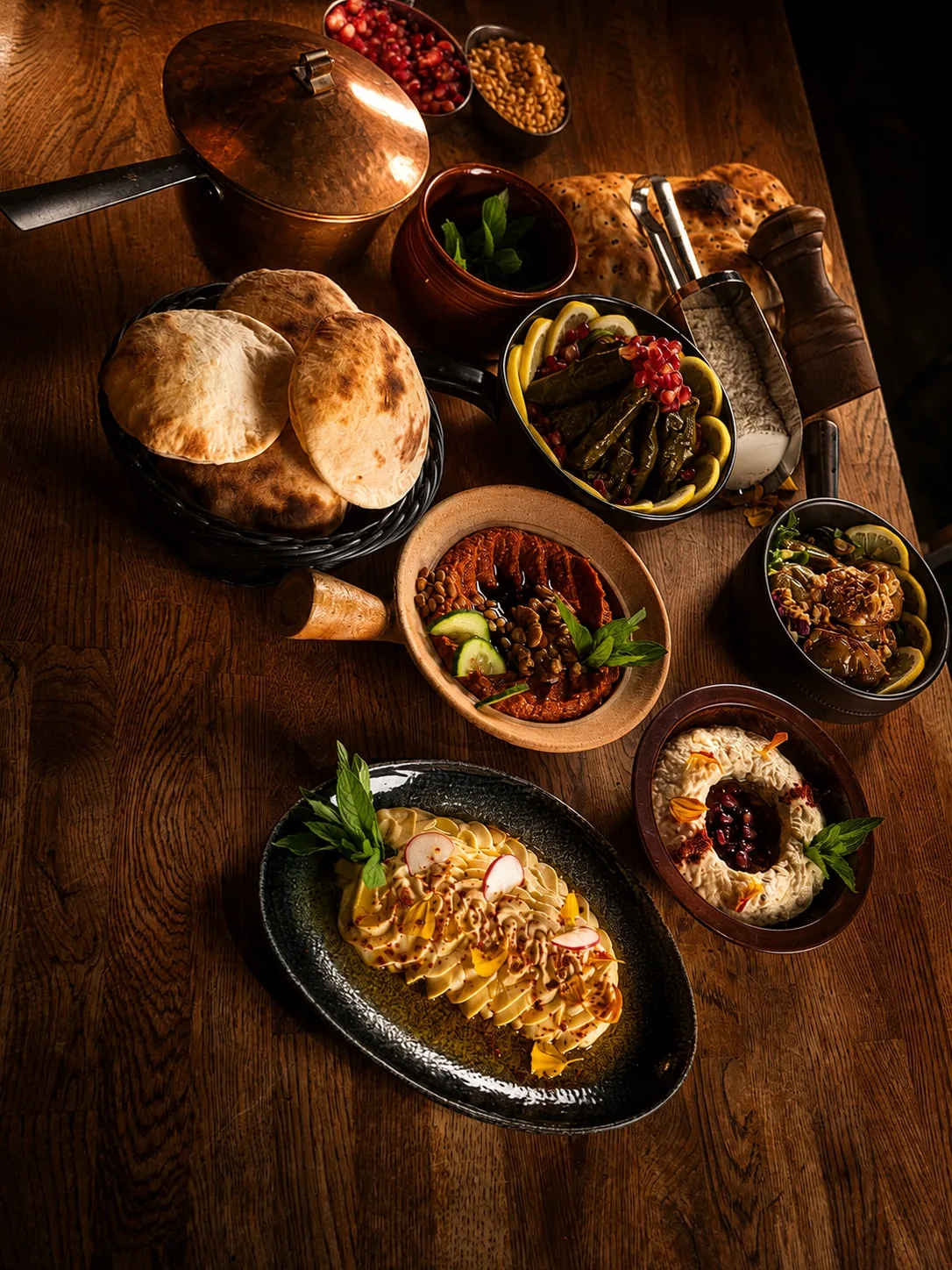 Mezebord med nybakat bröd och färgstarka rätter