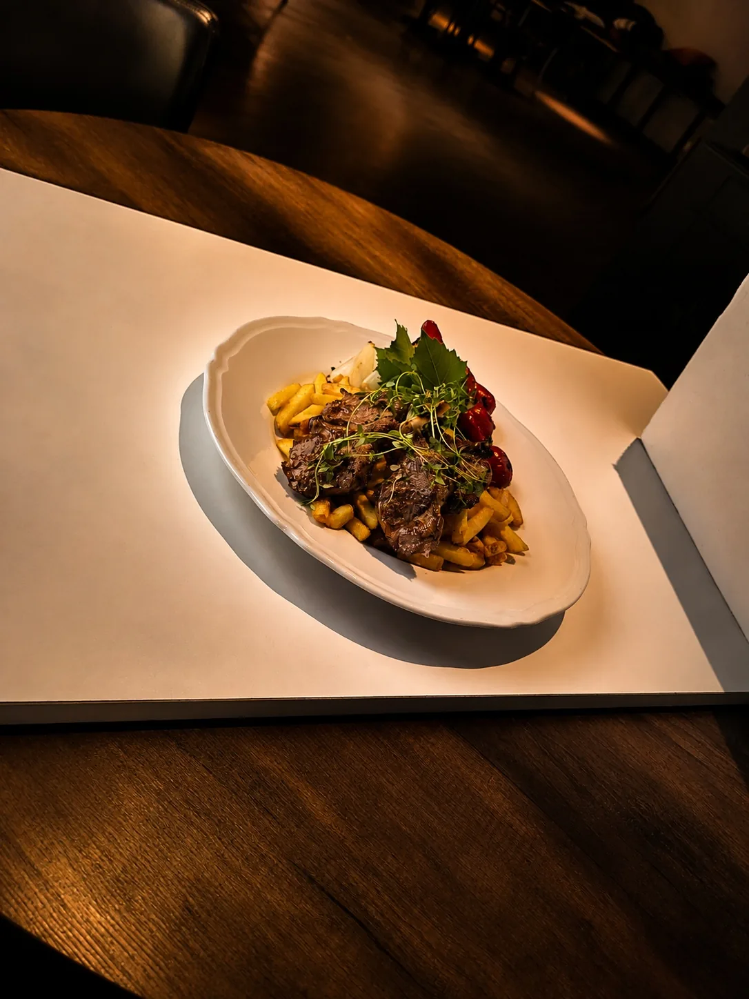 Grillad kötträtt upplagd på vitt fat